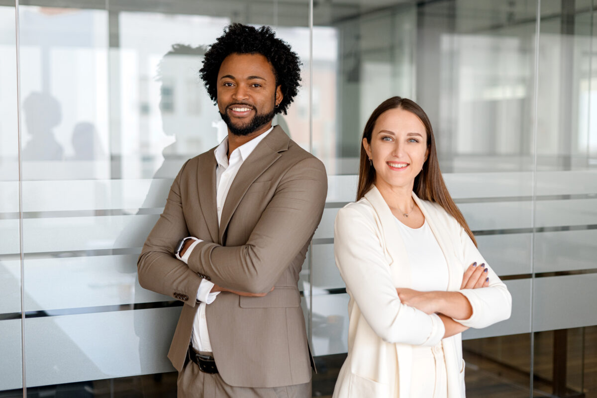 Due colleghi, un uomo e una donna, in ufficio sorridenti