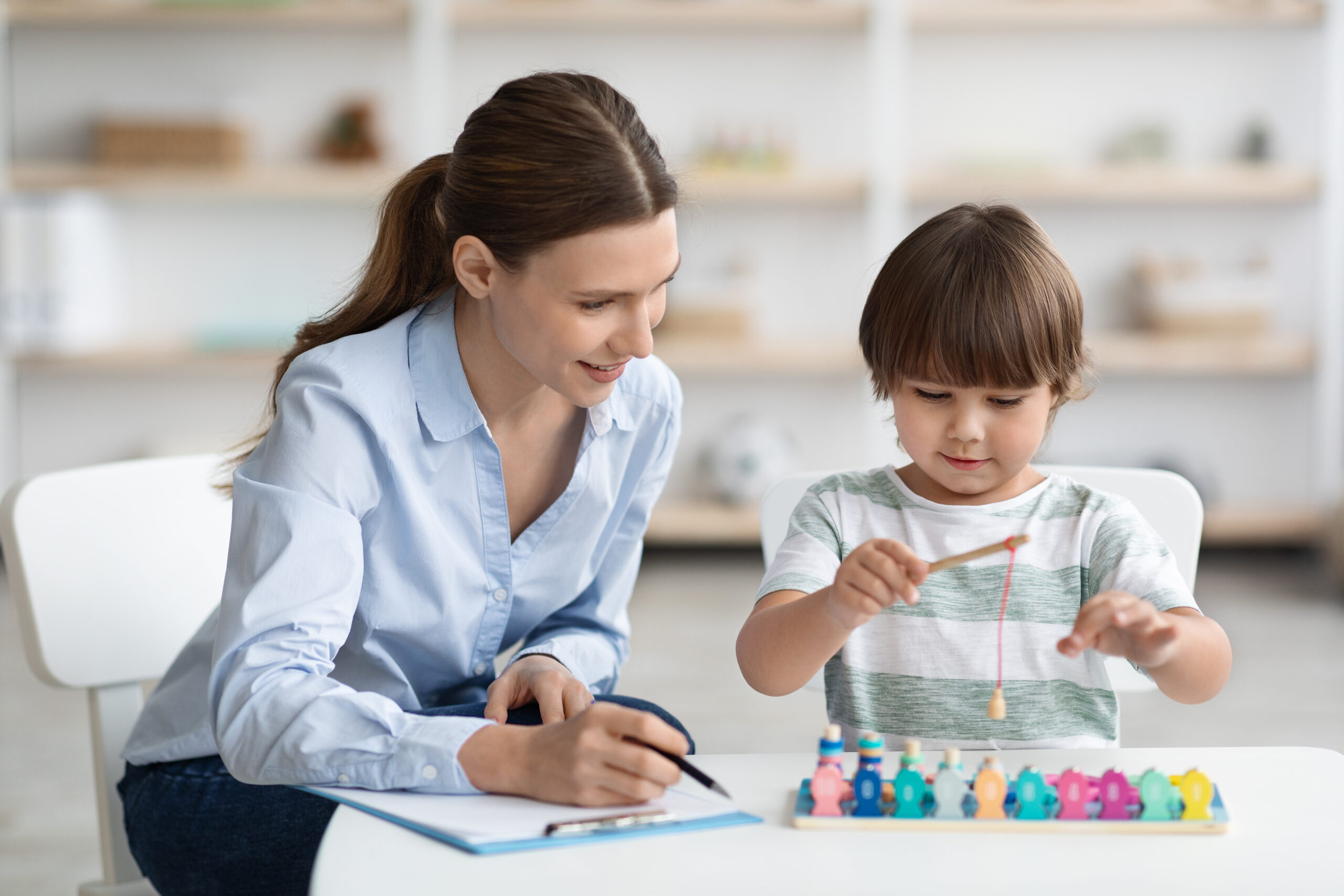 Psicologa supervisiona un bambino che gioca durante una sessione di terapia